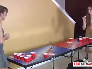 Две привлекателен момичета играя лента бира pong